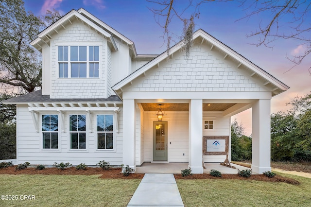 view of front of property with a front lawn and roof with shingles