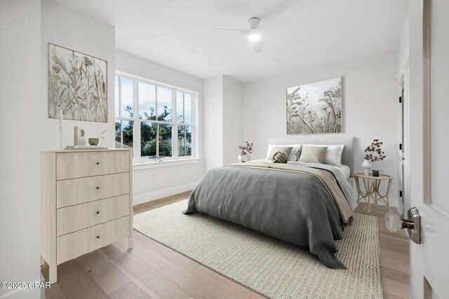 bedroom with ceiling fan, light wood-style flooring, and baseboards