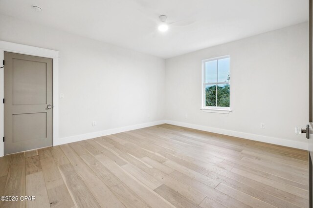 spare room with light wood-type flooring and baseboards