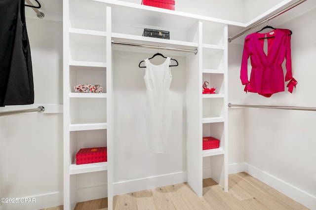 walk in closet with wood finished floors