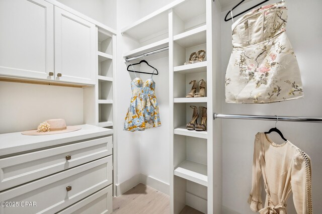 walk in closet with light wood-style flooring