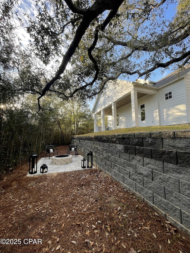 view of yard featuring an outdoor fire pit and a patio