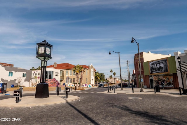 view of road with sidewalks, curbs, and street lights