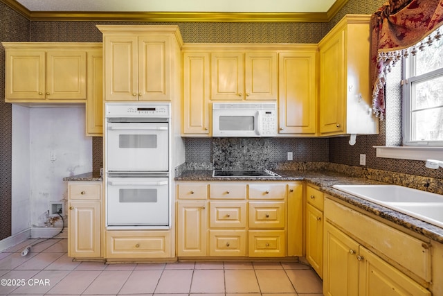 kitchen with backsplash, white appliances, sink, and light tile patterned floors