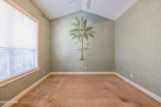 spare room with lofted ceiling, ceiling fan, and carpet flooring