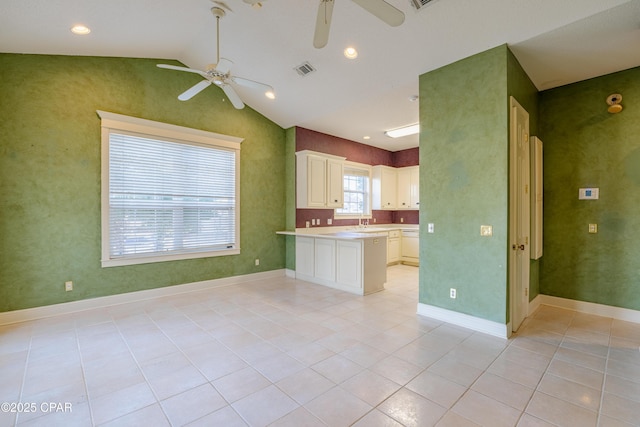 kitchen with lofted ceiling, sink, ceiling fan, light tile patterned flooring, and kitchen peninsula