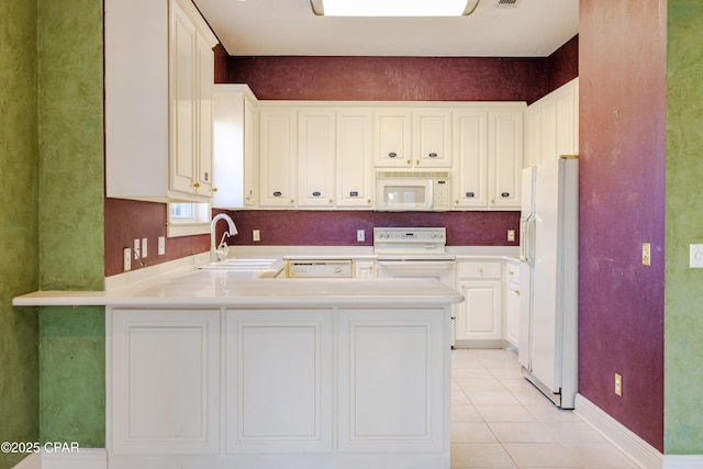 kitchen with sink, white cabinets, light tile patterned floors, kitchen peninsula, and white appliances