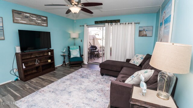 living room with ceiling fan and dark hardwood / wood-style flooring