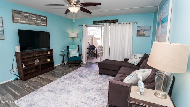 living room with dark wood-type flooring and ceiling fan