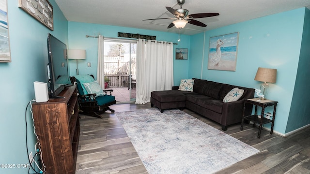 living room with dark hardwood / wood-style flooring and ceiling fan