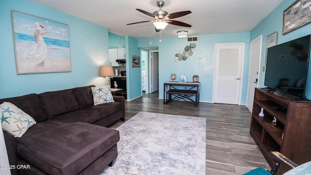 living room featuring dark hardwood / wood-style floors and ceiling fan