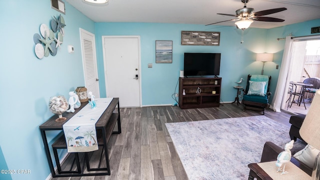 living room with dark hardwood / wood-style flooring and ceiling fan