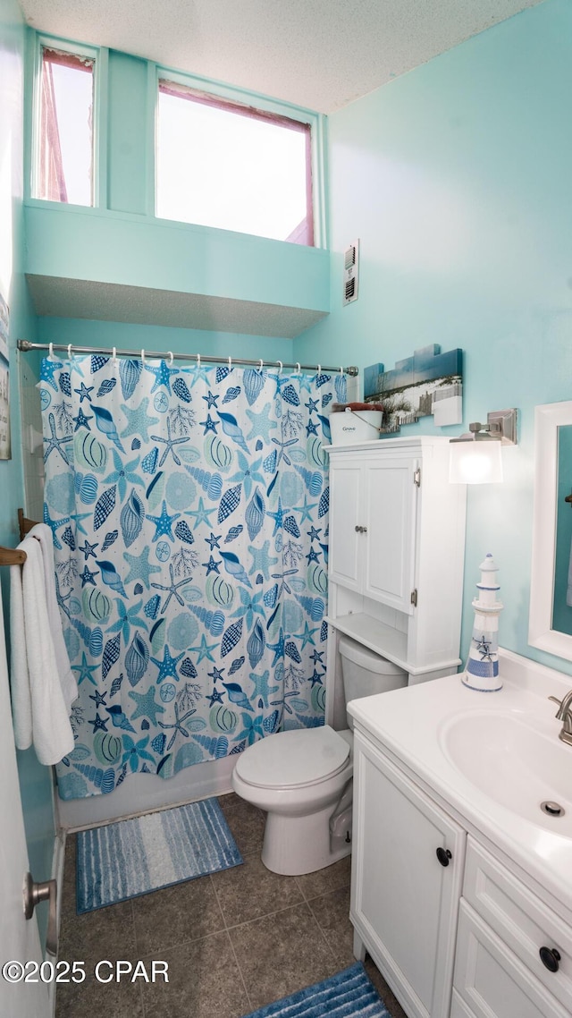 full bathroom with tile patterned floors, a healthy amount of sunlight, toilet, and vanity