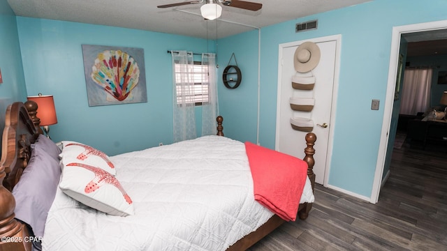 bedroom featuring a textured ceiling, dark hardwood / wood-style floors, and ceiling fan