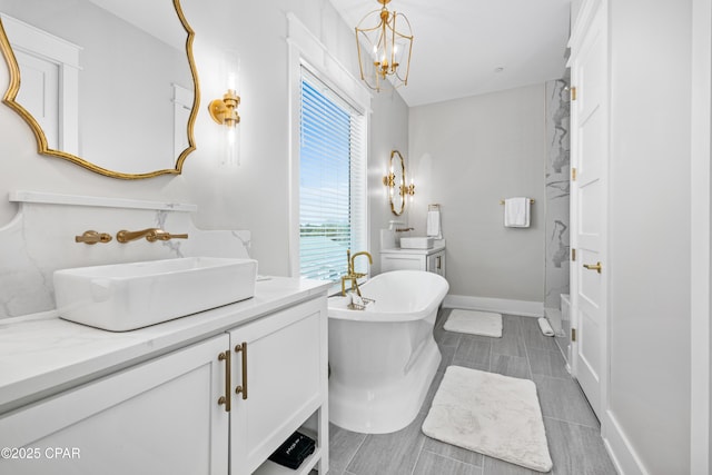 bathroom with vanity, a bath, and a chandelier