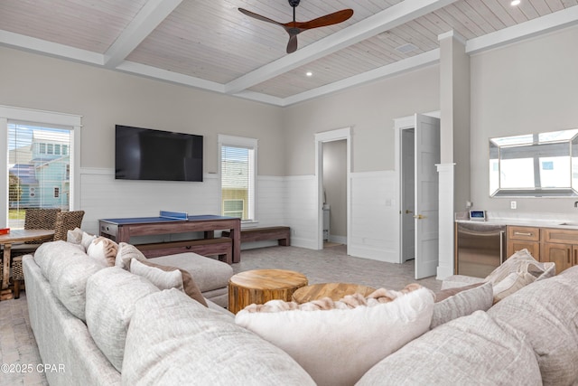 living room featuring ceiling fan, wood ceiling, and beamed ceiling