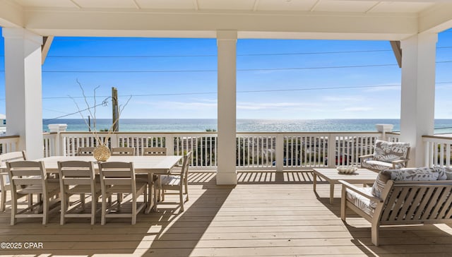 wooden deck featuring a water view and a beach view