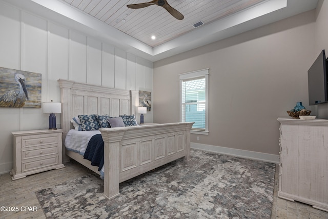 bedroom featuring wood ceiling, ceiling fan, and a tray ceiling