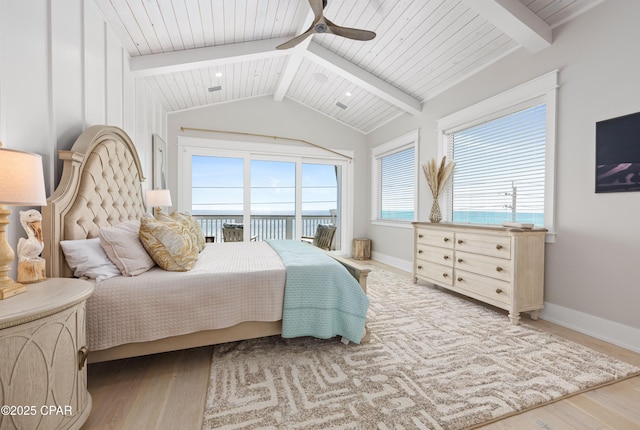 bedroom featuring ceiling fan, hardwood / wood-style floors, vaulted ceiling with beams, a water view, and access to outside