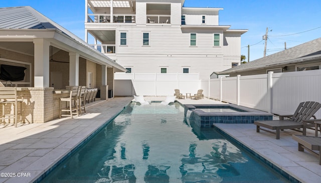 view of swimming pool with a bar, an in ground hot tub, and a patio