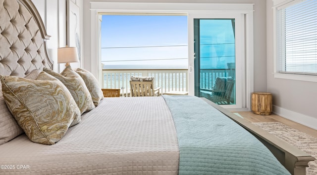 bedroom with a water view and hardwood / wood-style floors