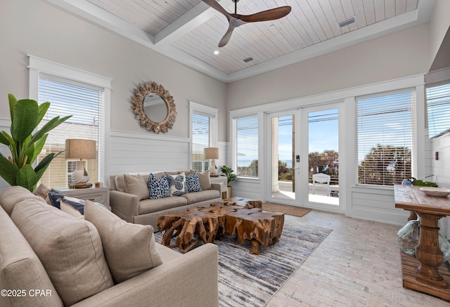 living room with ceiling fan, a healthy amount of sunlight, wooden ceiling, and beam ceiling