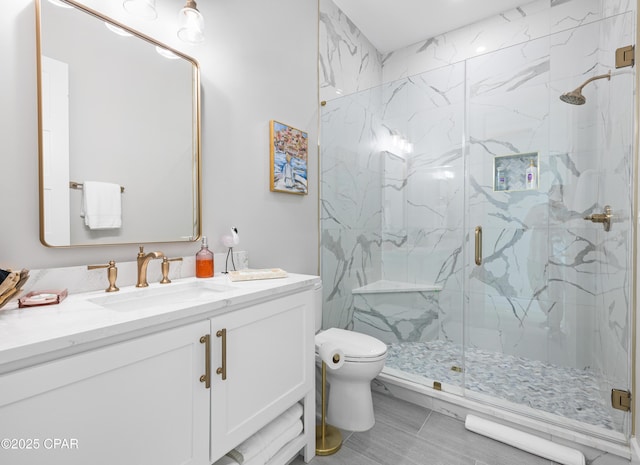 bathroom with vanity, toilet, and a shower with shower door