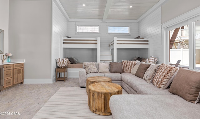 living room with beamed ceiling, a wealth of natural light, wooden ceiling, and wood walls