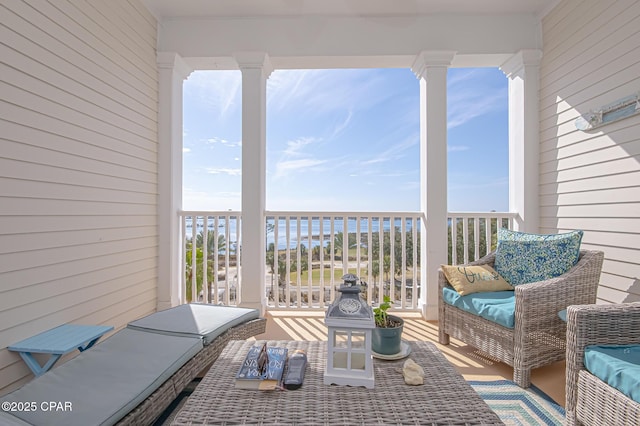 view of patio featuring a balcony and a water view