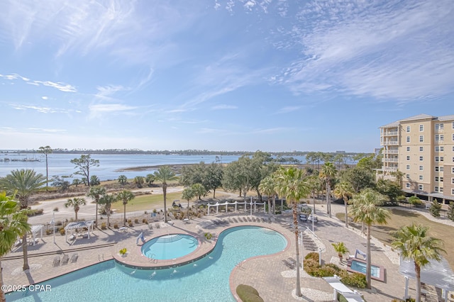 view of pool with a community hot tub, a water view, and a patio area