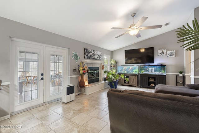 tiled living room featuring vaulted ceiling, french doors, and ceiling fan