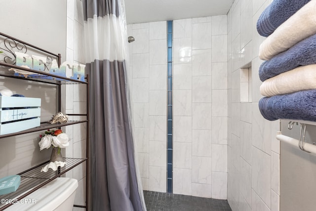 bathroom featuring a shower with curtain and toilet