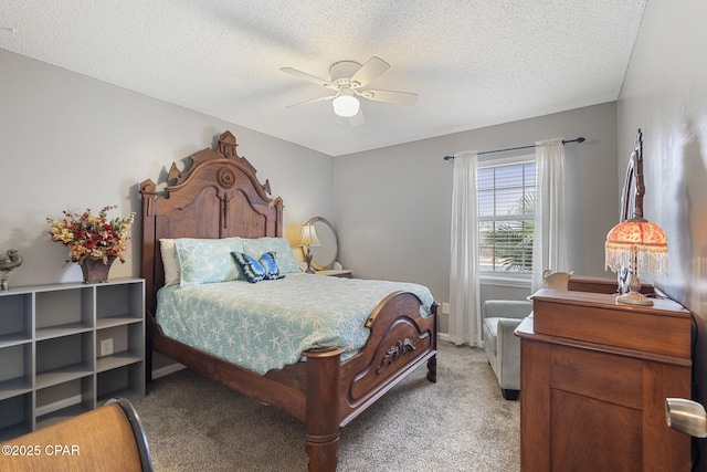 bedroom with ceiling fan, light colored carpet, and a textured ceiling