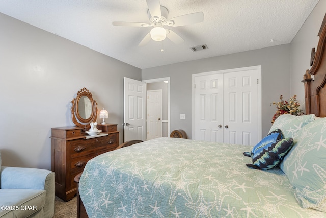 bedroom featuring ceiling fan, carpet floors, a closet, and a textured ceiling