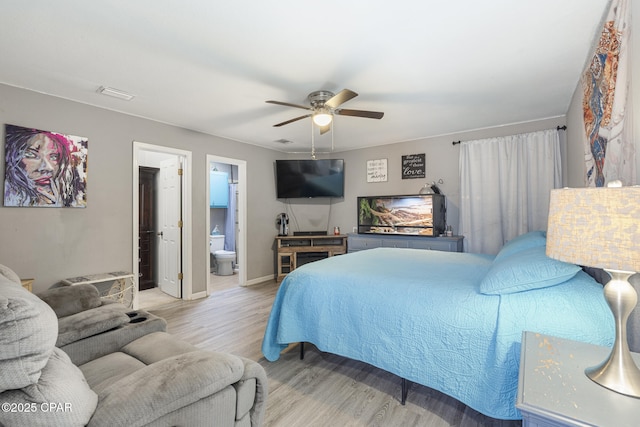 bedroom with ceiling fan, connected bathroom, and light hardwood / wood-style floors