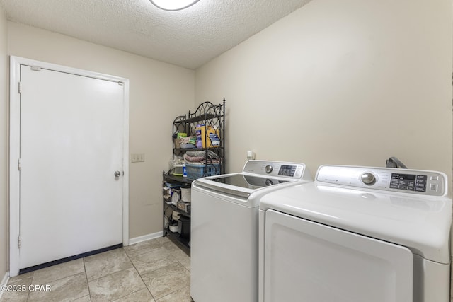 laundry room featuring independent washer and dryer, a textured ceiling, and light tile patterned floors