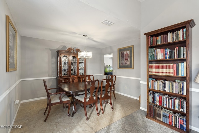 tiled dining area featuring an inviting chandelier