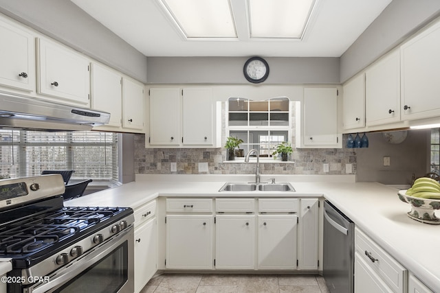 kitchen with white cabinetry, appliances with stainless steel finishes, sink, and backsplash