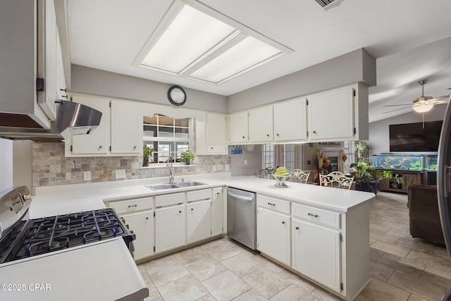 kitchen with sink, white cabinetry, tasteful backsplash, appliances with stainless steel finishes, and kitchen peninsula