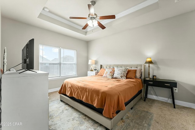 bedroom featuring carpet floors, a raised ceiling, crown molding, and baseboards
