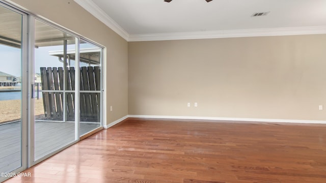 spare room with hardwood / wood-style flooring, crown molding, and ceiling fan