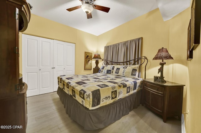 bedroom with a closet, ceiling fan, light wood-type flooring, and baseboard heating