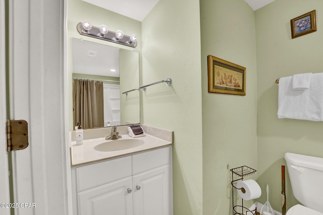 bathroom with toilet, vanity, and visible vents