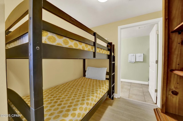 bedroom with baseboards, visible vents, and wood finished floors