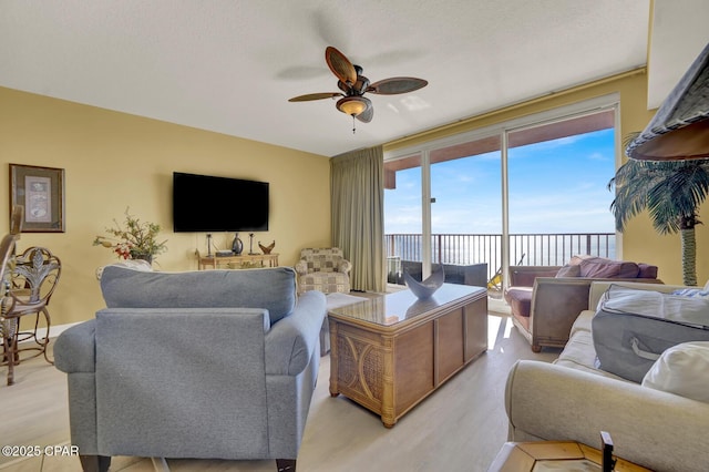 living area with light wood-style floors and ceiling fan