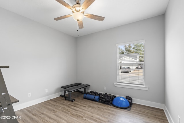 workout room featuring a ceiling fan, wood finished floors, and baseboards