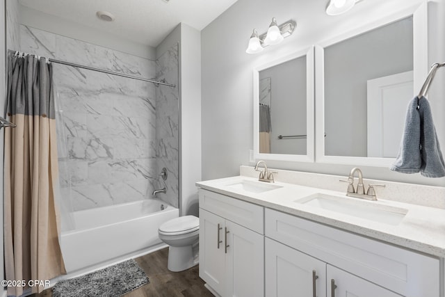 bathroom with a sink, shower / bath combo with shower curtain, toilet, and wood finished floors