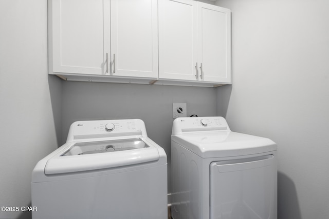 laundry room with washer and clothes dryer and cabinet space