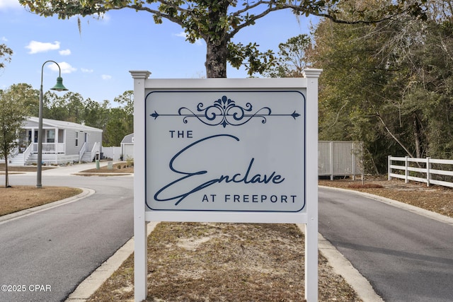 community / neighborhood sign featuring fence