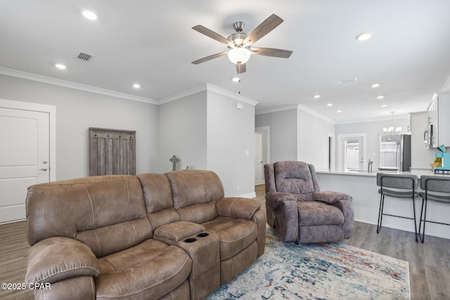 living room featuring light wood-style flooring, recessed lighting, visible vents, and ornamental molding